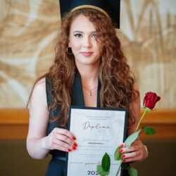 Absolventă ținând diploma de absolvire