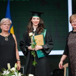 O tânără absolventă zâmbește în timpul ceremoniei de absolvire, evidențiind bucuria