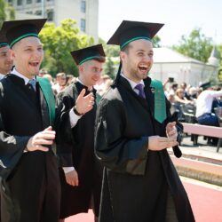 Studenți care se bucură la ceremonia de absolvire