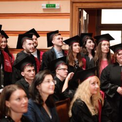 Studenți în robe de absolvire la ceremonia de absolvire