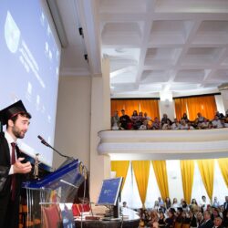 Absolvent susținând un discurs în fața audienței