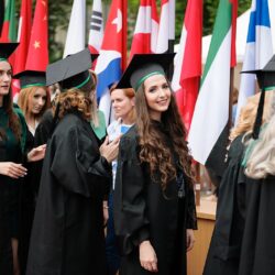 Grup de studenți în robe de absolvire, pregătindu-se pentru ceremonie