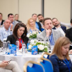 Participanți la conferință, ascultând cu atenție.